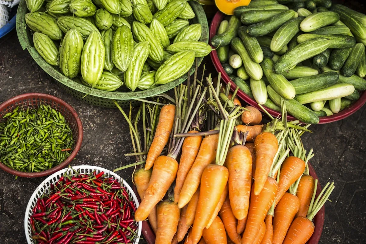 Hands arranging fresh produce and ceramics at a California makers market